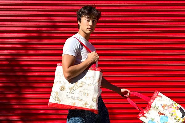 Griddle Bag — Jimmy Dean Person walking outside in front of red background carrying two Jimmy Dean Griddle Bags