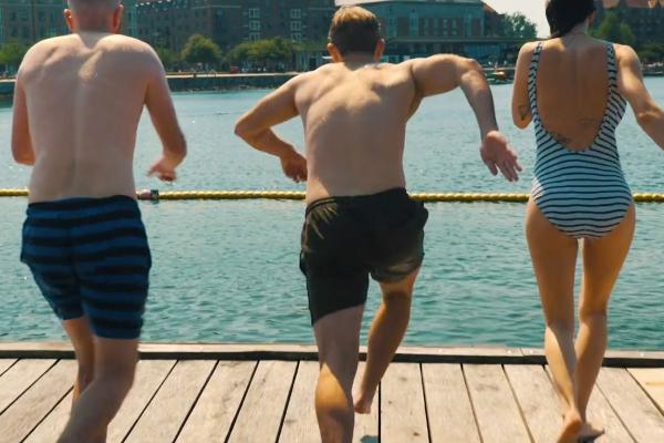 Life Quality Insurance — Greater Copenhagen Region Three people in swimsuits standing on a dock overlooking water