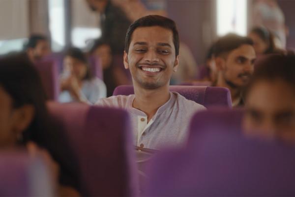 Confirmed Seat — Cadbury Celebrations Man smiling on a train with purple seats