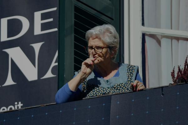 Anyone Could be a Spy — Prime Video Italian woman standing on a balcony looking down at the street below