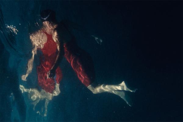 The Athletes Code — Powerade Shot of competitive swimmer in red suit with reflection in the water