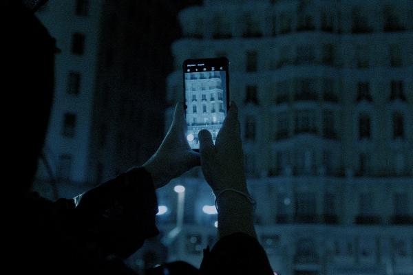 The Ghost Campaign - Burger King Person taking a photo on their phone in at nighttime outside in the dark
