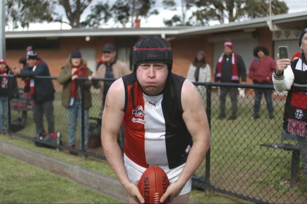 When Our Game Has its Moments — AAMI australian rules football player holding ball and looking into the camera