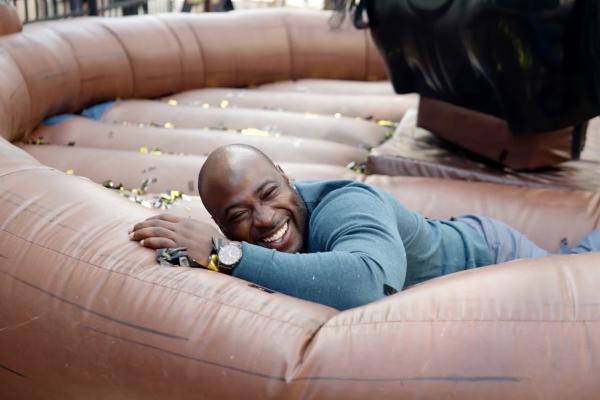 A man who has fallen off a mechanical bucking bronco laughing